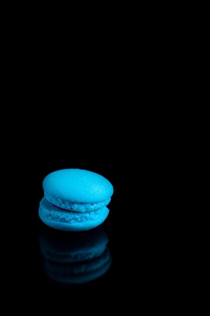 Macarons français colorés sur fond noir.