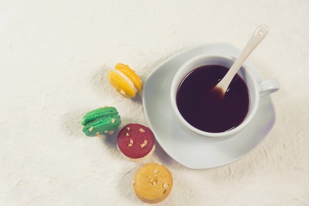 Macarons français colorés avec une tasse de café couleur vintage