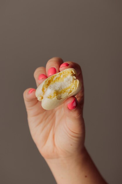 Macarons français dans les mains de la femme