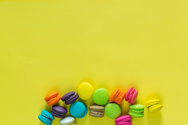 Macarons français doux et colorés ou macaron sur fond jaune Dessert manger avec du thé ou du café