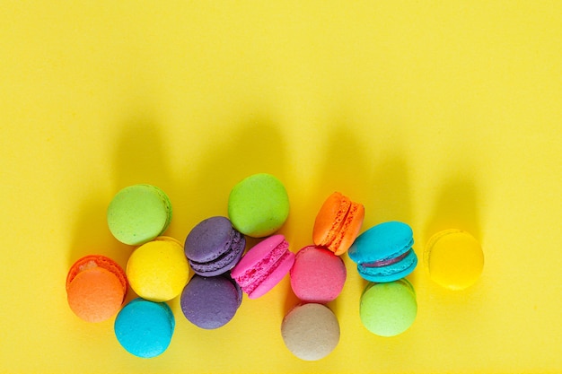 Macarons français doux et colorés ou macaron sur fond jaune Dessert manger avec du thé