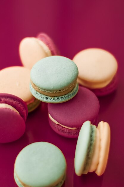 Macarons français sur fond rose cerise café chic parisien dessert aliments sucrés et gâteau macaron pour la conception de toile de fond de vacances de marque de confiserie de luxe