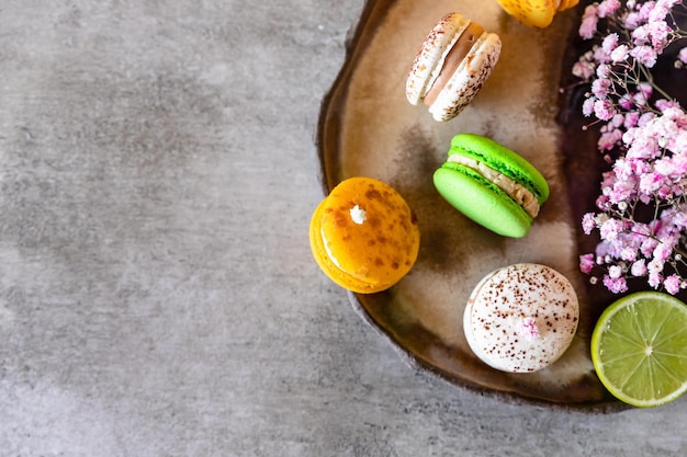 Photo macarons français ou italiens colorés au citron vert et aux fleurs fond sucré alimentaire