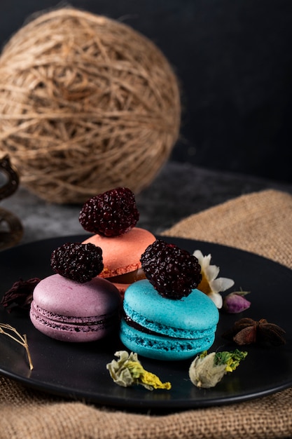 Macarons français tricolores sur une soucoupe noire