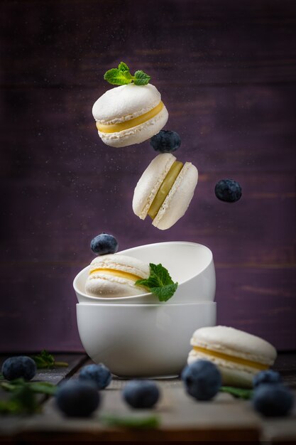 macarons de gâteau français à la pistache et à la mandarine remplissant la lévitation d'un dessert