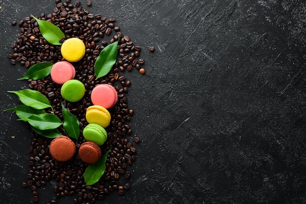 Photo macarons gâteaux colorés sur fond de pierre noire vue de dessus espace libre pour votre texte