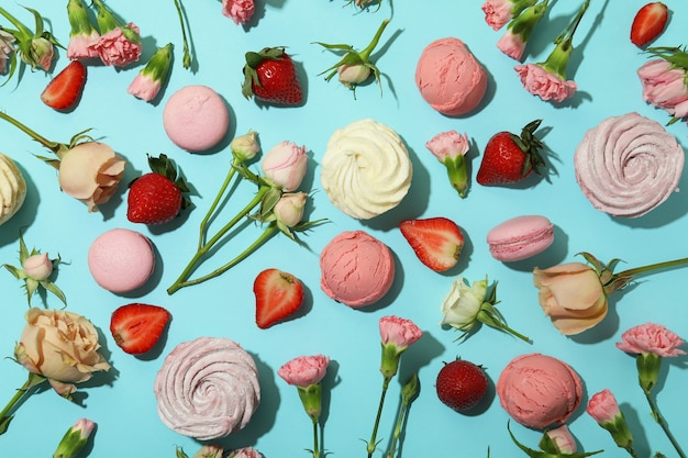 Macarons, guimauves, fleurs et fraises sur fond bleu