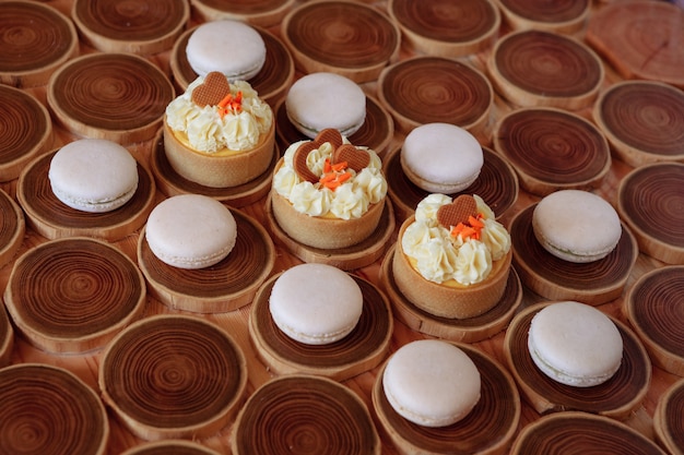 Macarons humbles et délicats blancs sur un fond en bois le ton pastel de la crème à l'intérieur du...