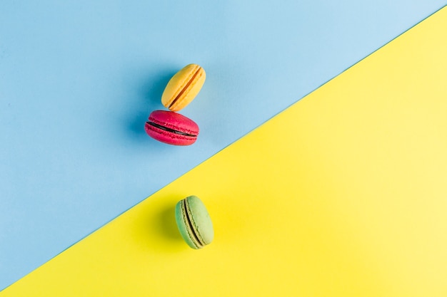 Macarons multicolores sur un fond bleu et jaune, vue de dessus, Flatley avec fond