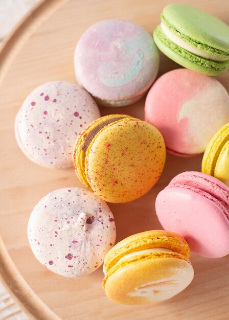 Macarons Multicolores Sur Fond De Bois Avec Des Lumières Douces Et Des Ombres. Macarons Doux Sur Table Sur Fond Clair.