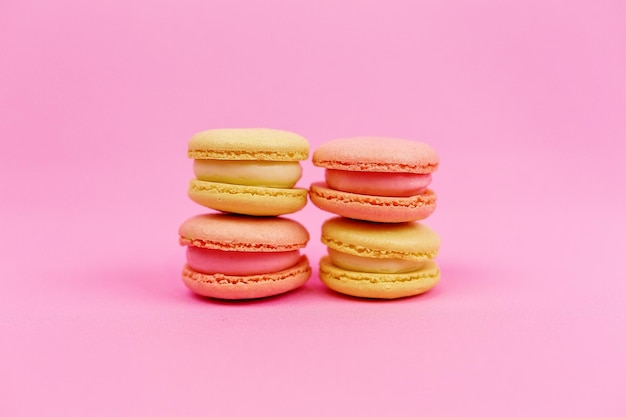 Macarons multicolores en forme de tours sur fond rose