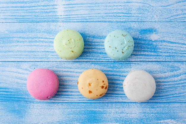 Macarons multicolores sur une surface bleue,