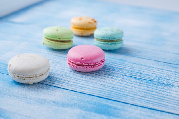 Macarons multicolores sur une surface bleue,