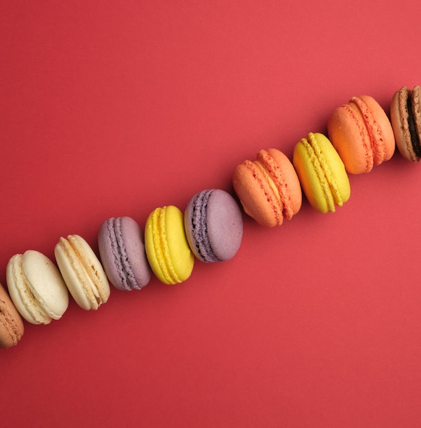 Macarons ronds multicolores cuits au four avec crème se trouvent dans une ligne