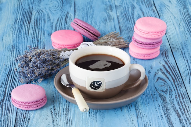 Macarons roses et tasse de café près de levender séché