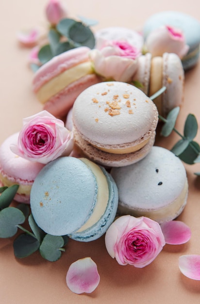 Macarons savoureux avec de belles roses sur fond marron