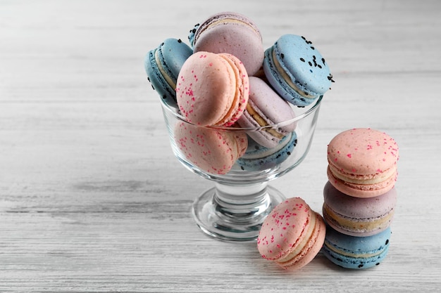 Macarons savoureux dans un plat en verre sur une table en bois