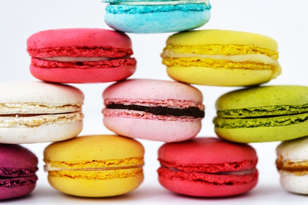 Macarons sous la forme d'une pyramide sur une surface blanche. Orientation horizontale, gros plan.