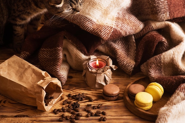 Macarons sucrés sur planche de bois avec une tasse de café et une bougie allumée Photo d'ambiance Contenu pour les réseaux sociaux