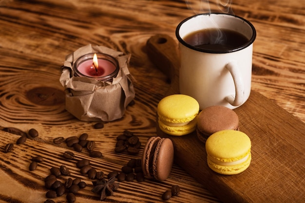 Macarons sucrés sur planche de bois avec une tasse de café et une bougie allumée Photo d'ambiance Contenu pour les réseaux sociaux