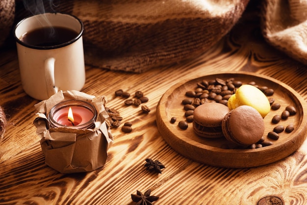 Macarons sucrés sur planche de bois avec une tasse de café et une bougie allumée Photo d'ambiance Contenu pour les réseaux sociaux