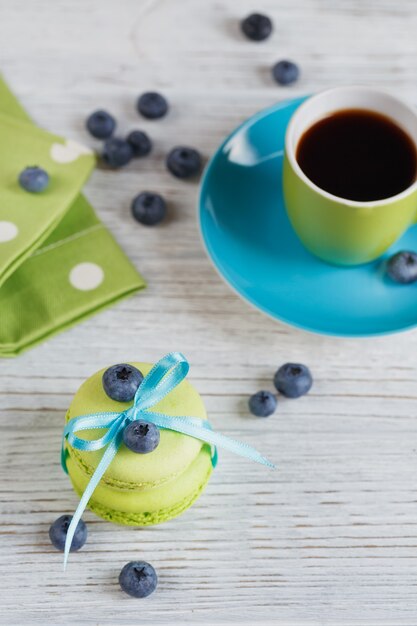 Macarons verts aux myrtilles sur table en bois blanc