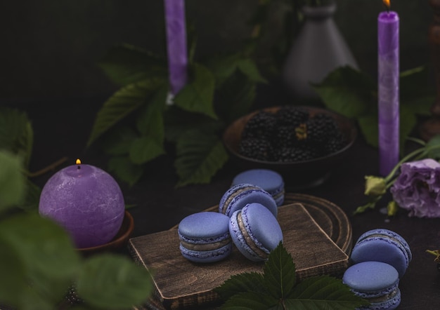 Macarons violets et mûres sur un fond vert foncé