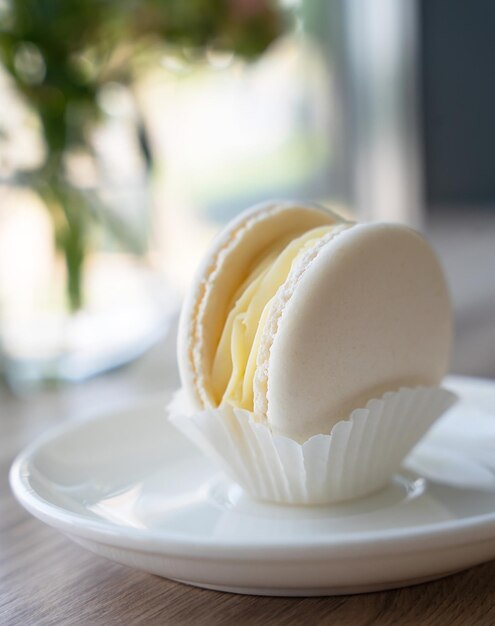 Photo macaroon à la vanille ou à la noix de coco sur l'assiette blanche dans le café focus sélectif