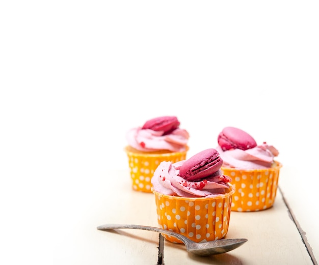 Macaroons sur des cupcakes sur un fond blanc