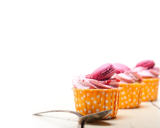 Macaroons sur des cupcakes sur un fond blanc