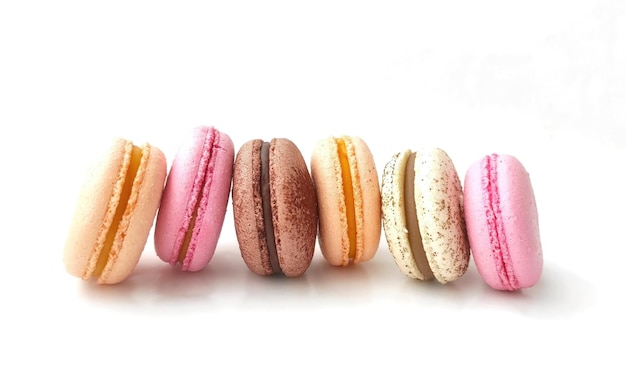 Macaroons français colorés empilés sur fond blanc Macaroons colorés savoureux assortis