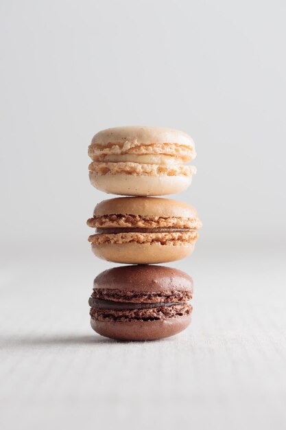 Des macaroons naturels faits à la main en pastel écologique coloré sur fond blanc Cadeau pour la fête internationale de la femme le 8 mars Jour de la Saint-Valentin Stack vertical