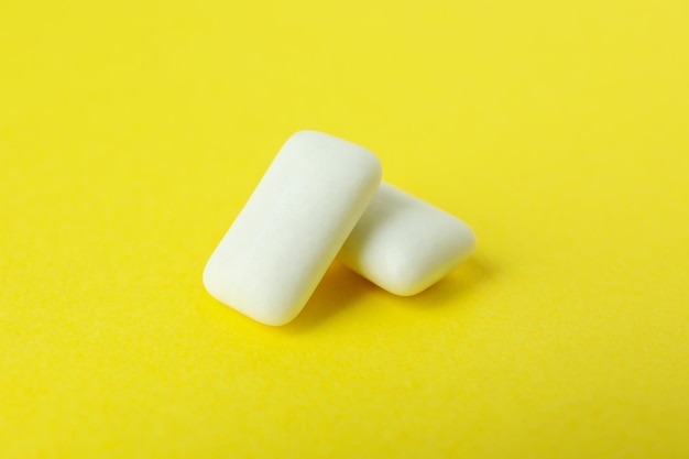 Mâcher ou chewing-gum sur fond jaune gros plan