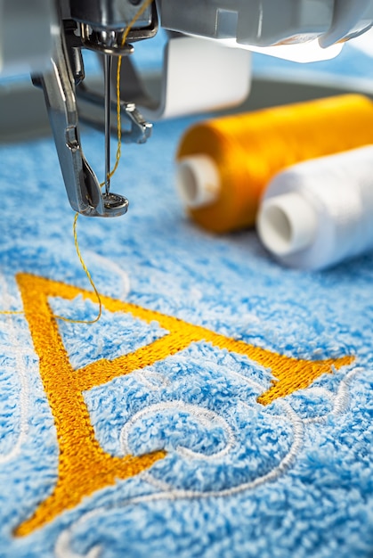 Machine à broder et logo alphabet sur serviette