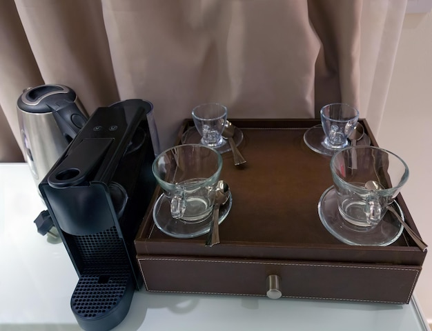 Photo machine à café automatique bouilloire électrique et tasse à thé en verre pour le thé ou le café dans la cuisine set de préparation du café dans une chambre d'hôtel avec bouilloire électrique en acier inoxydable tasses propres cuillères à thé matin