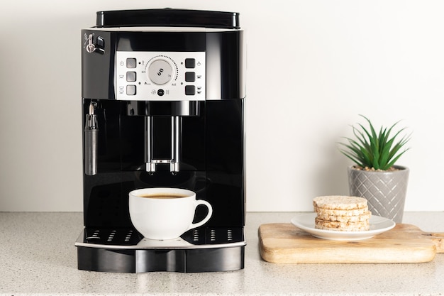 Machine à café expresso moderne avec une tasse à l'intérieur du gros plan de cuisine.