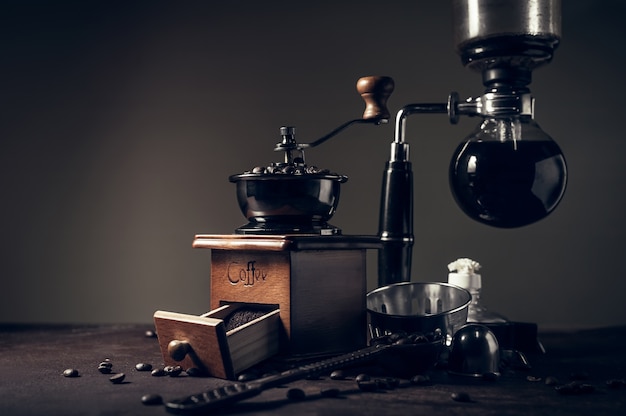 Machine à café siphon japonais et moulin à café sur le vieux fond de table de cuisine.