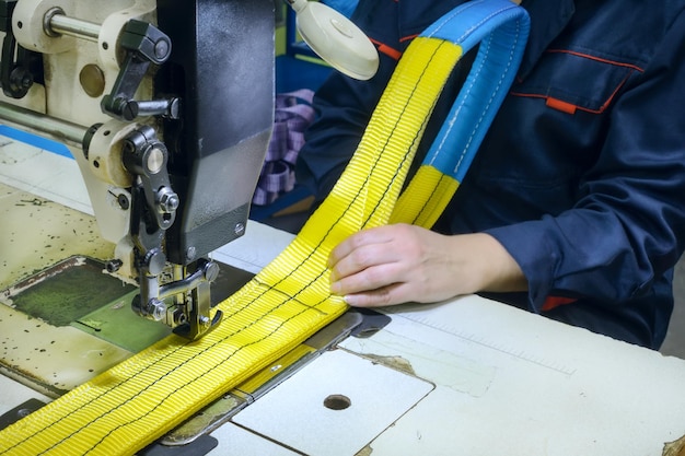 La machine à coudre industrielle coud une sangle à cliquet