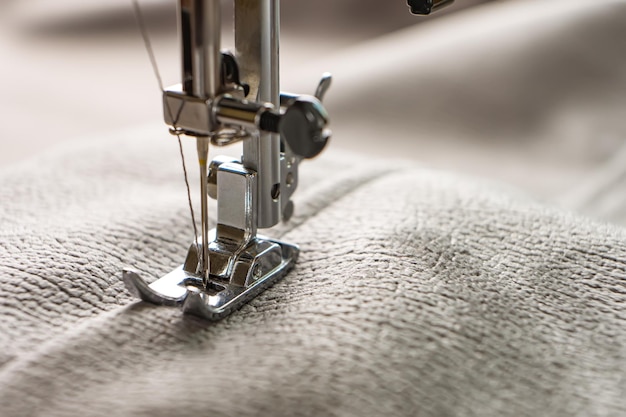 Machine à coudre moderne et tissu gris processus de couture fait main passe-temps bricolage entreprise réparation