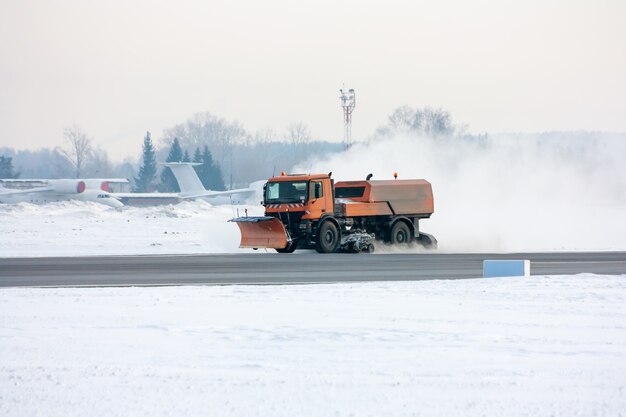 La machine de déneigement nettoie la voie de circulation principale à l'aéroport