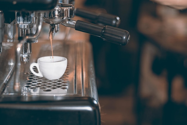 Machine à expresso faisant du café, expresso doré qui coule. Café expresso