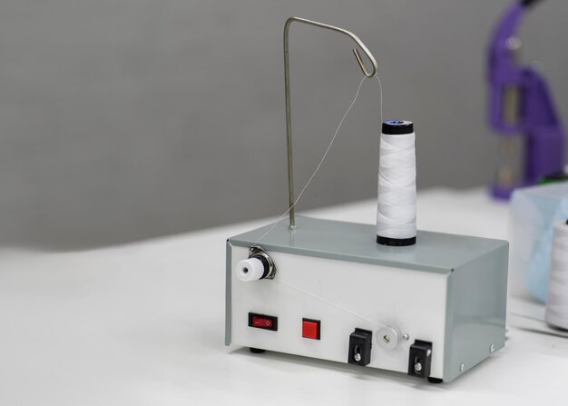 Photo machine à filer en rouleau de fil blanc dans une usine de couture