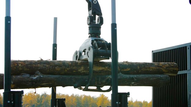 Photo une machine forestière charge un camion à bois sur le site d'atterrissage de la machine forestière