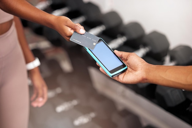 Machine de paiement et femme avec une carte de crédit au gymnase pour un contrat de remise en forme ou un achat Facture de carte et fille payant son entraîneur personnel après une séance d'entraînement ou un exercice dans un centre sportif