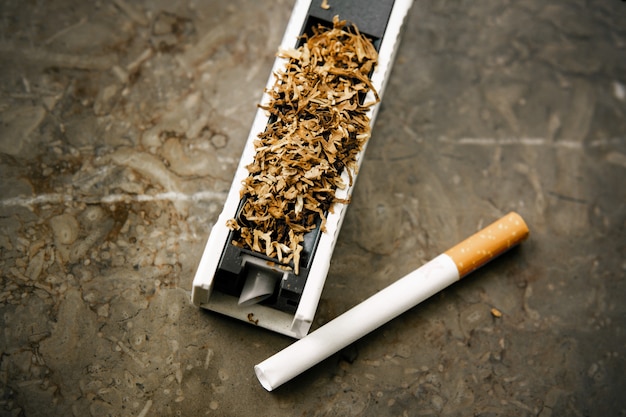 Photo la machine pour bourrer des cigarettes avec du tabac.