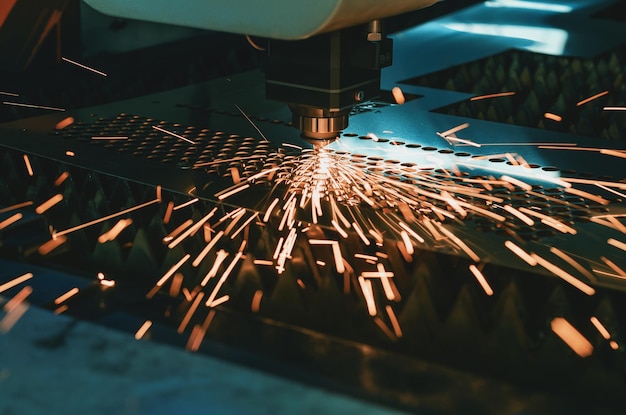 Machine pour la découpe laser du métal La tête laser coupe la feuille avec un faisceau de dispersion des étincelles