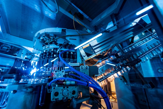 La machine de remplissage automatique verse de l'eau dans des bouteilles en plastique pour animaux de compagnie dans une usine de boissons moderne