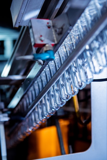 La machine de remplissage automatique verse de l'eau dans des bouteilles en plastique pour animaux de compagnie dans une usine de boissons moderne