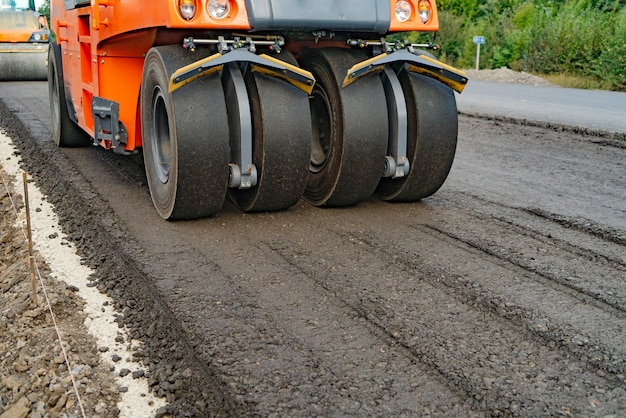 La machine à rouleaux fonctionne sur l'asphalte.