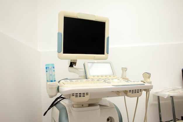 Machine à ultrasons moderne dans un hôpital sur fond blanc avec un écran vide